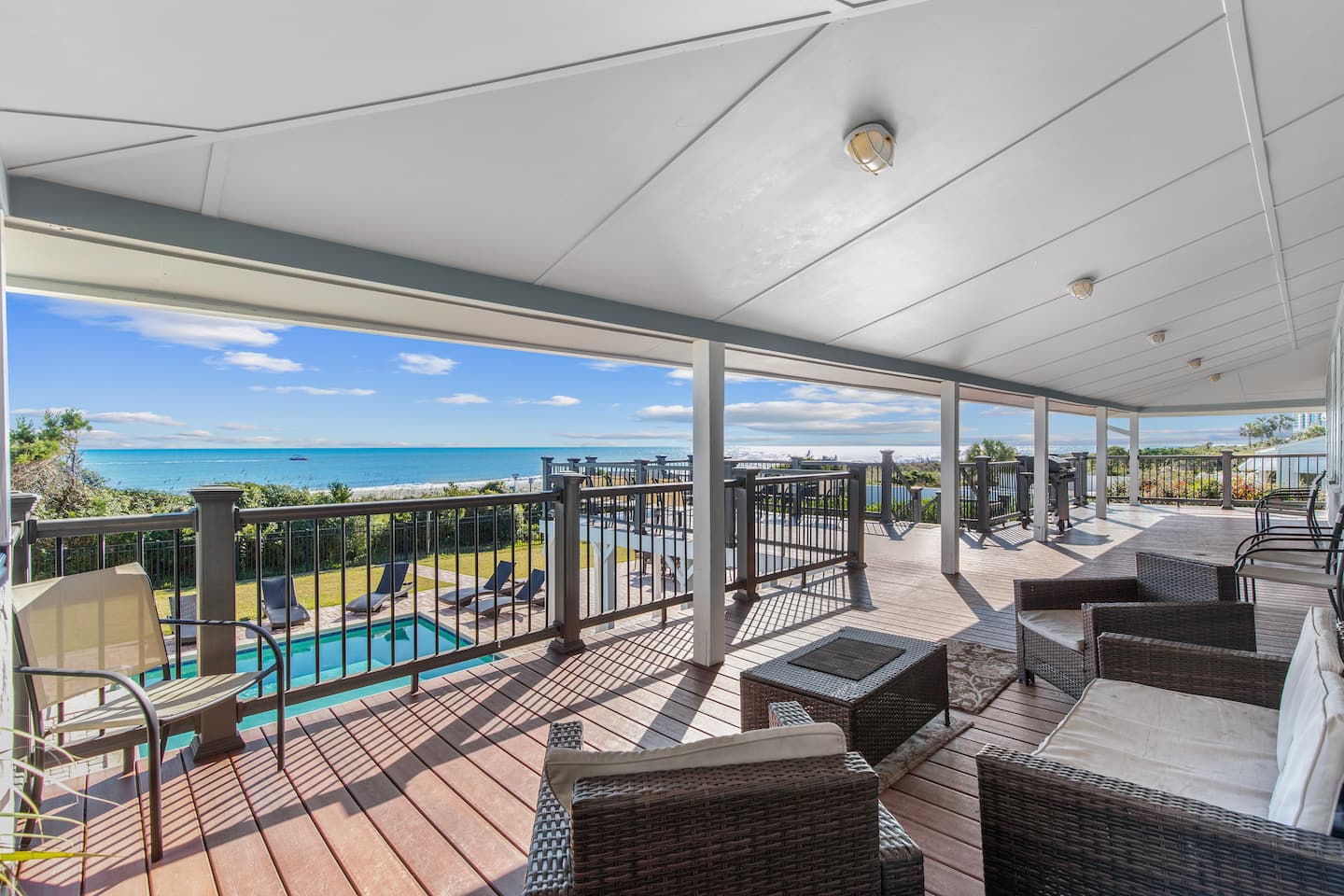 Covered deck overlooking the Golden Mile house’s swimming pool and oceanfront yard.