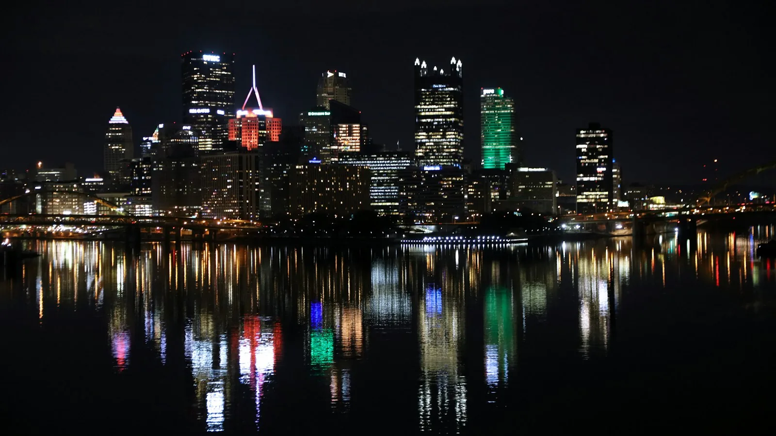Pittsburgh skyline illuminated across the river at night