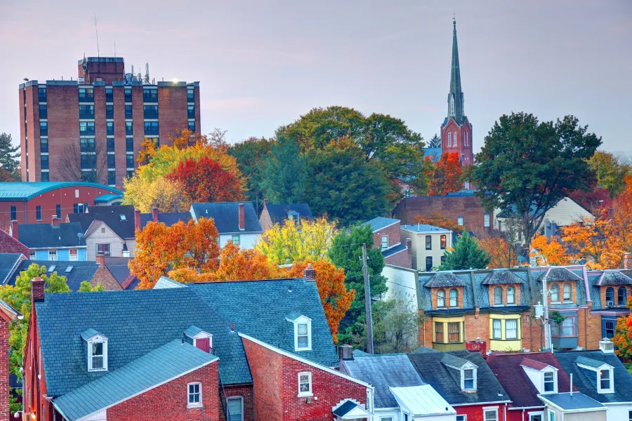 Harrisburg skyline and church steeple framed by autumn trees