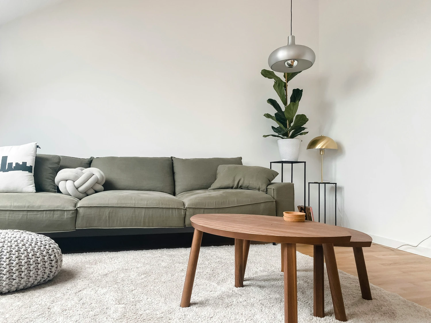 Minimalist living room with a gray sofa and round wood coffee table