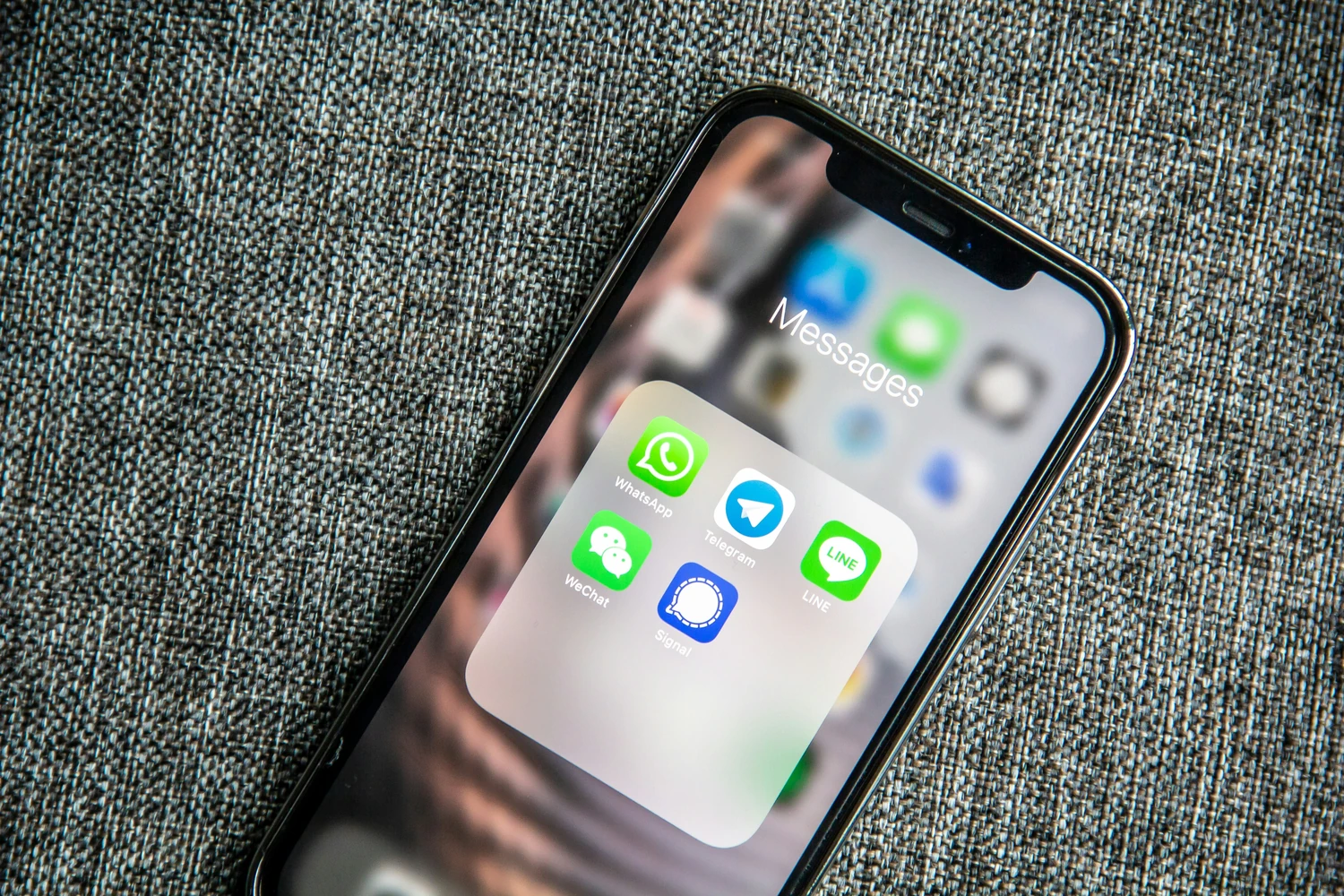 Smartphone home screen resting on gray fabric