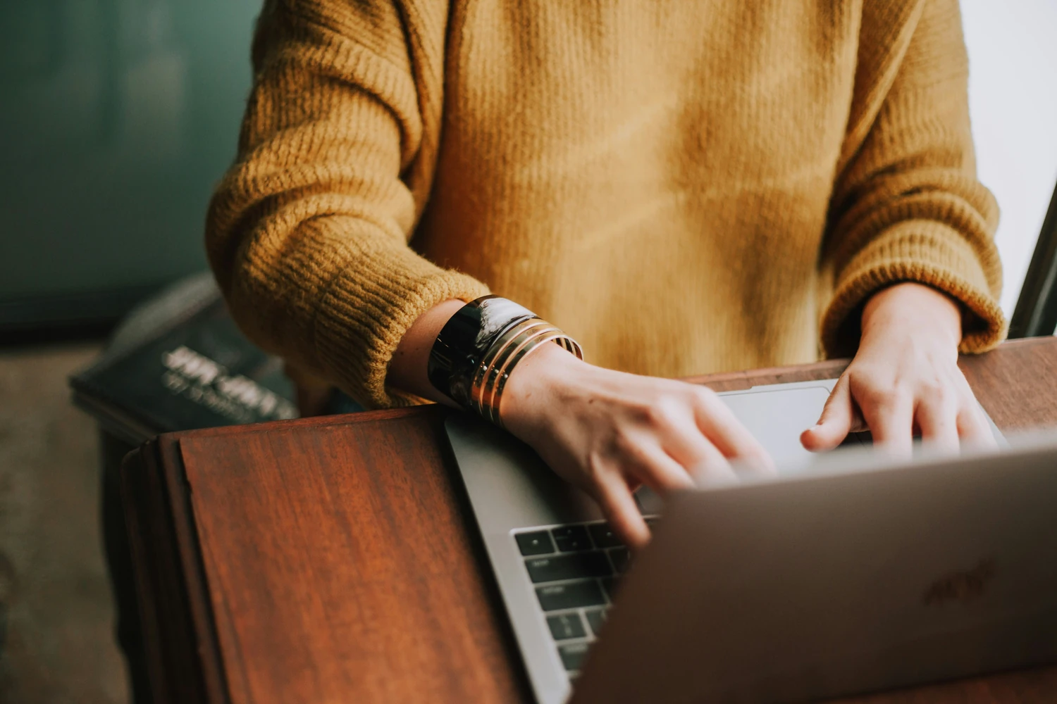 Person working on a laptop at a wooden table