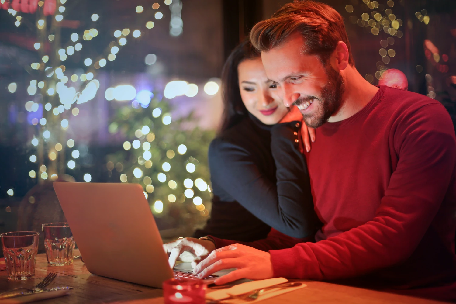 Smiling couple reviewing a booking together on a laptop