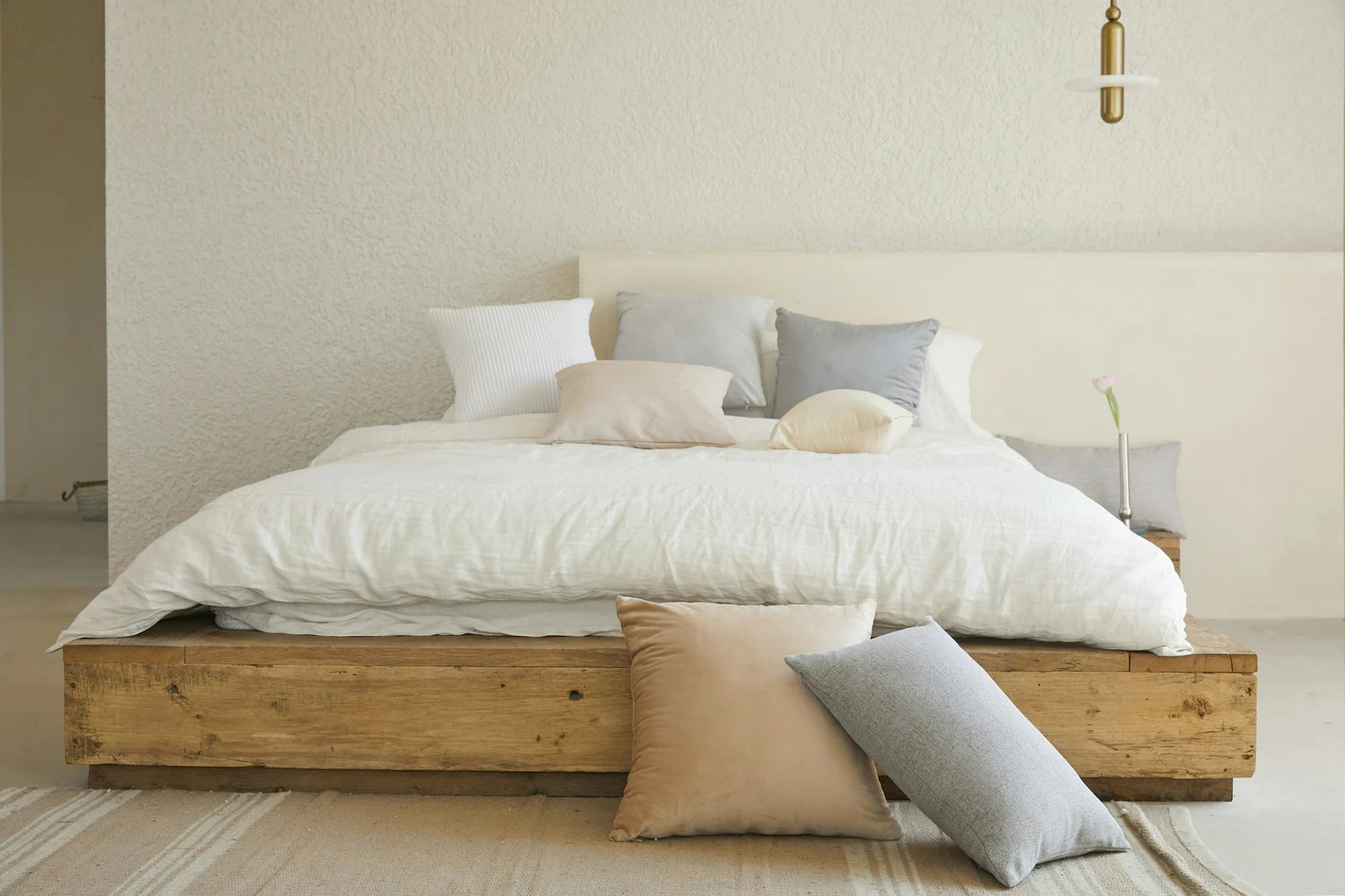 White bed and pillows on a low wooden platform