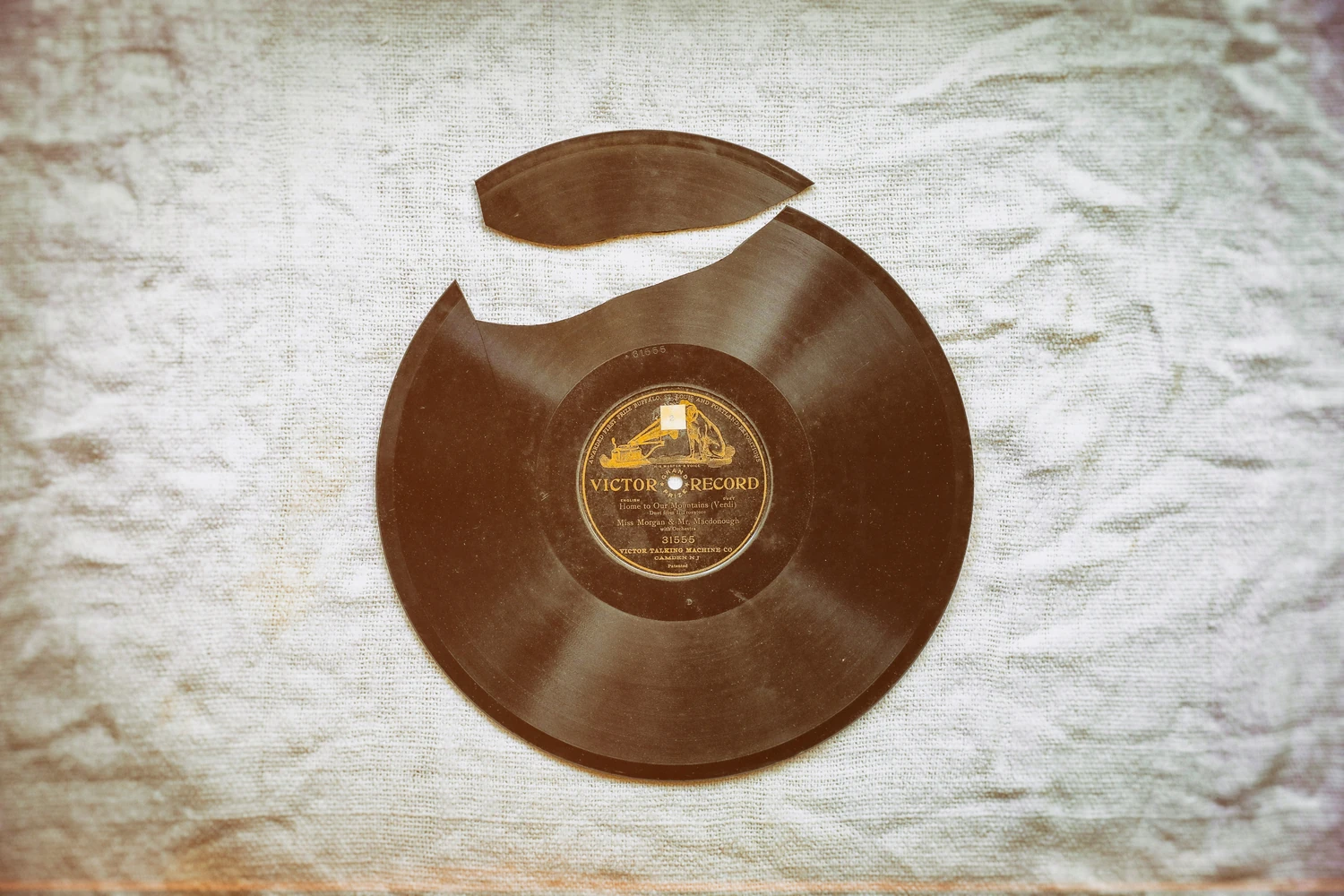 Broken vinyl record on white fabric