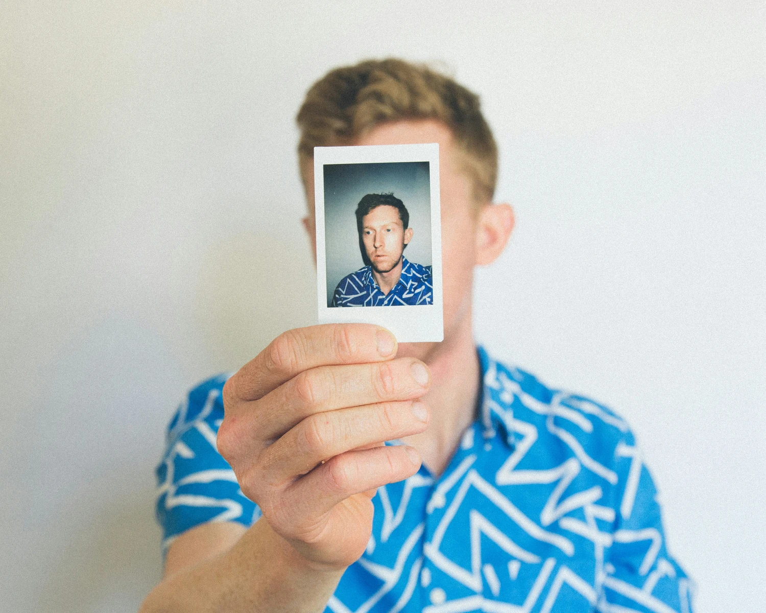Man holding a smartphone displaying an identification portrait