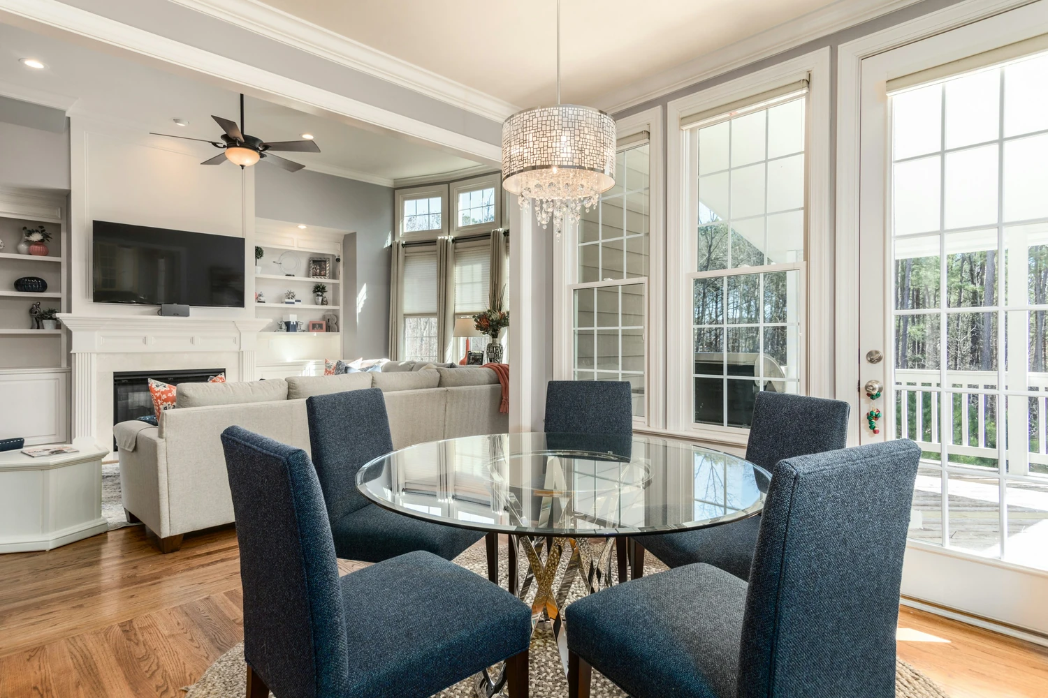 Bright dining area with a glass table beside a white kitchen