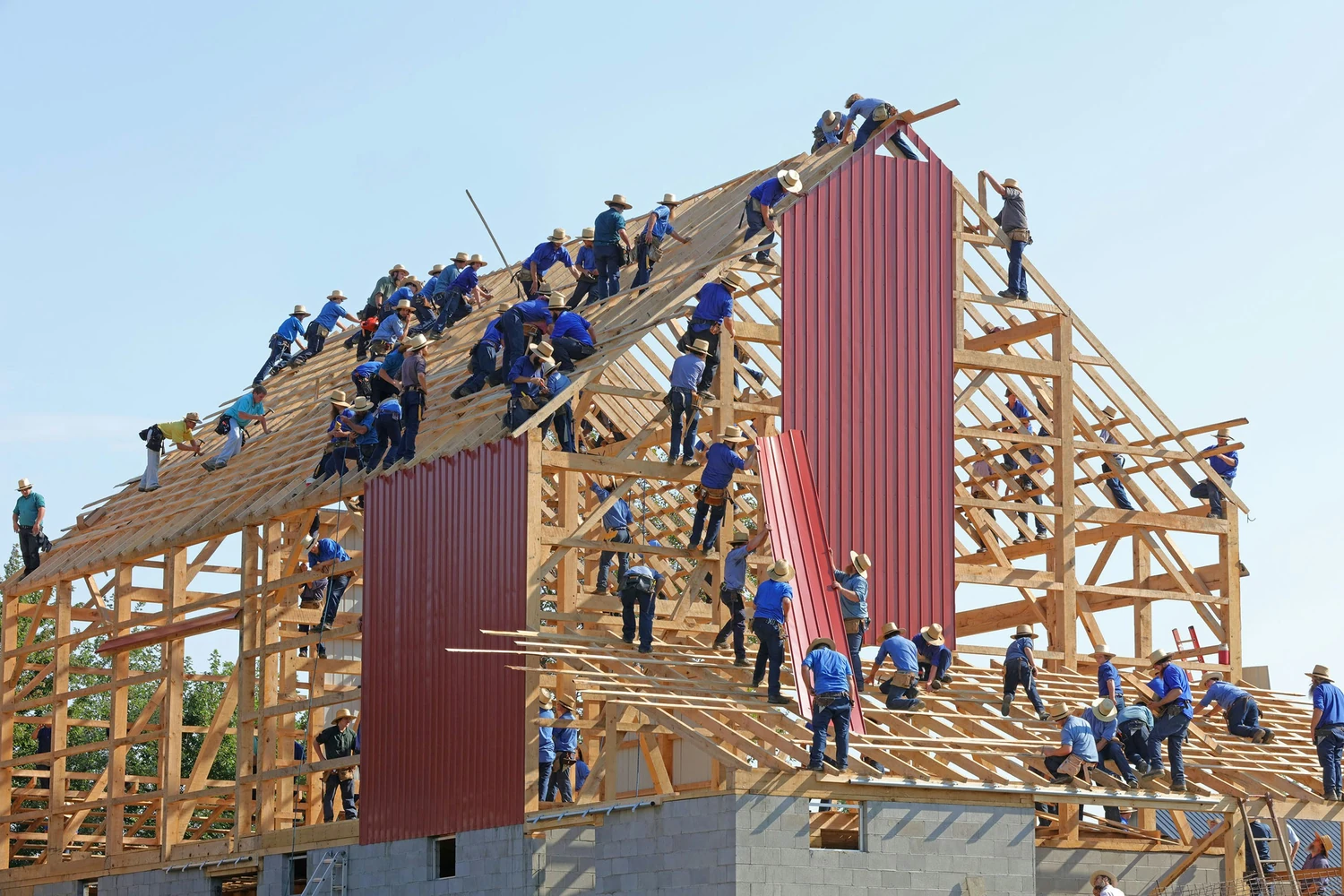Community volunteers raising a timber building frame