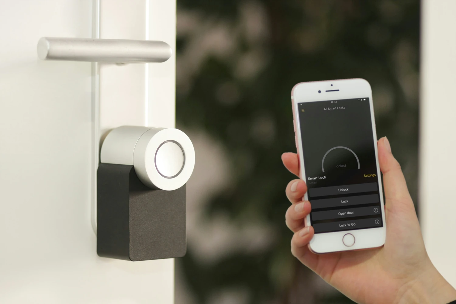 Smartphone controlling a connected lock on a white door