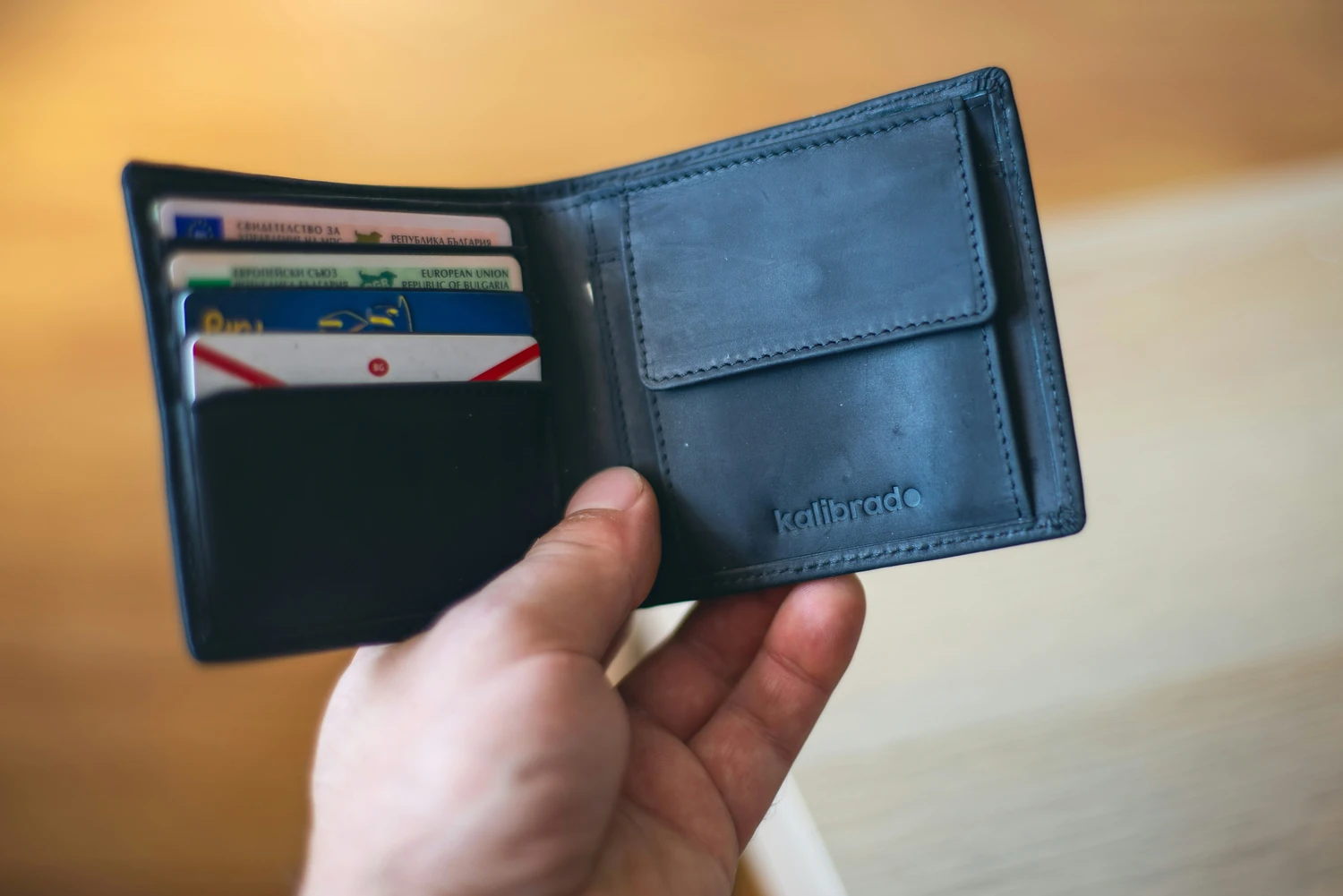 Open blue wallet holding several payment cards