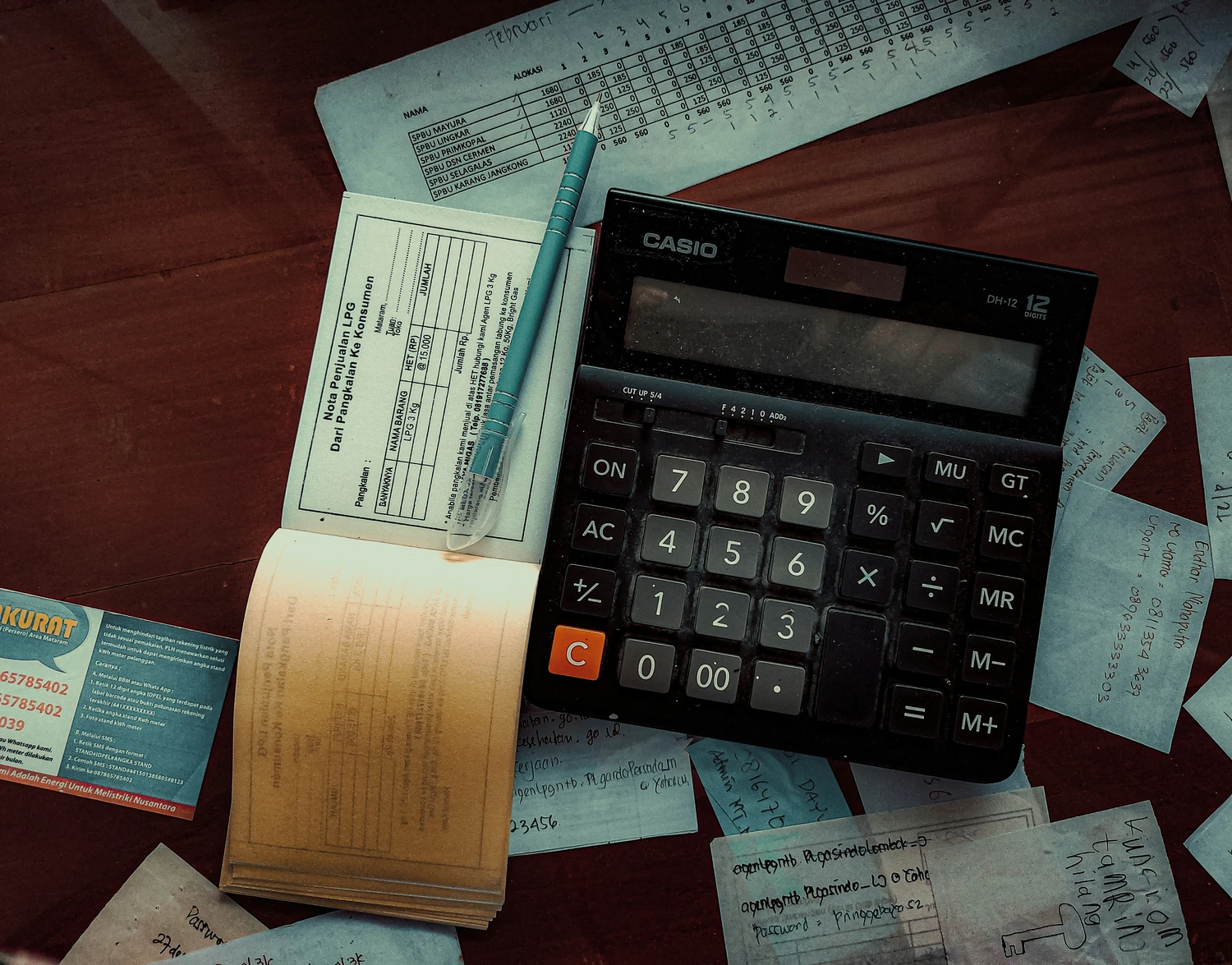 Calculator and receipts spread across a wooden table